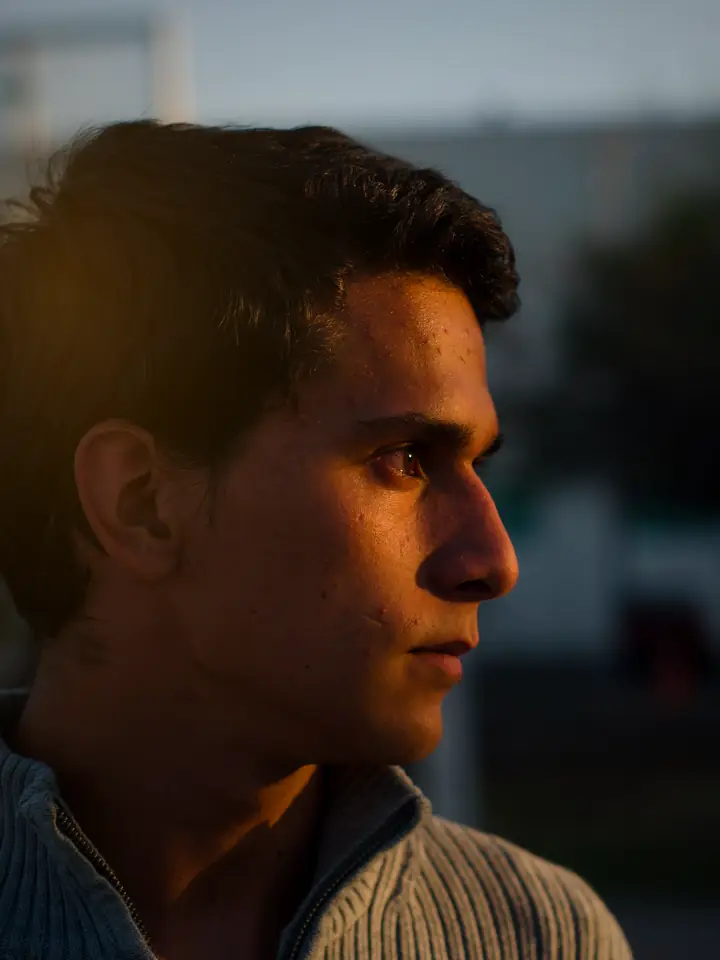 A young man in profile in golden-hour light