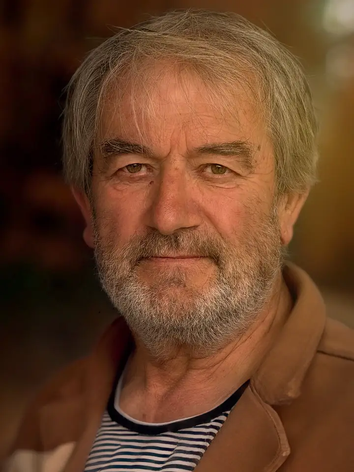 An older man with a grey beard in warm afternoon light